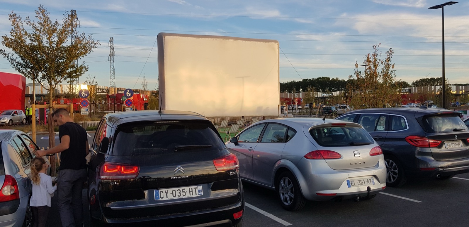 Die aufgeblasene Riesenkinoleinwand „Hallucine“ im Freien, in der Nähe geparkte Autos